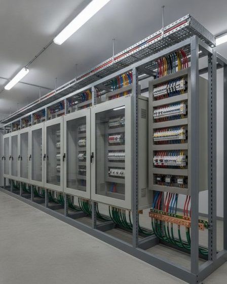 Sala de painéis elétricos industriais de baixa tensão com quadros de distribuição e bandejas de cabos organizadas